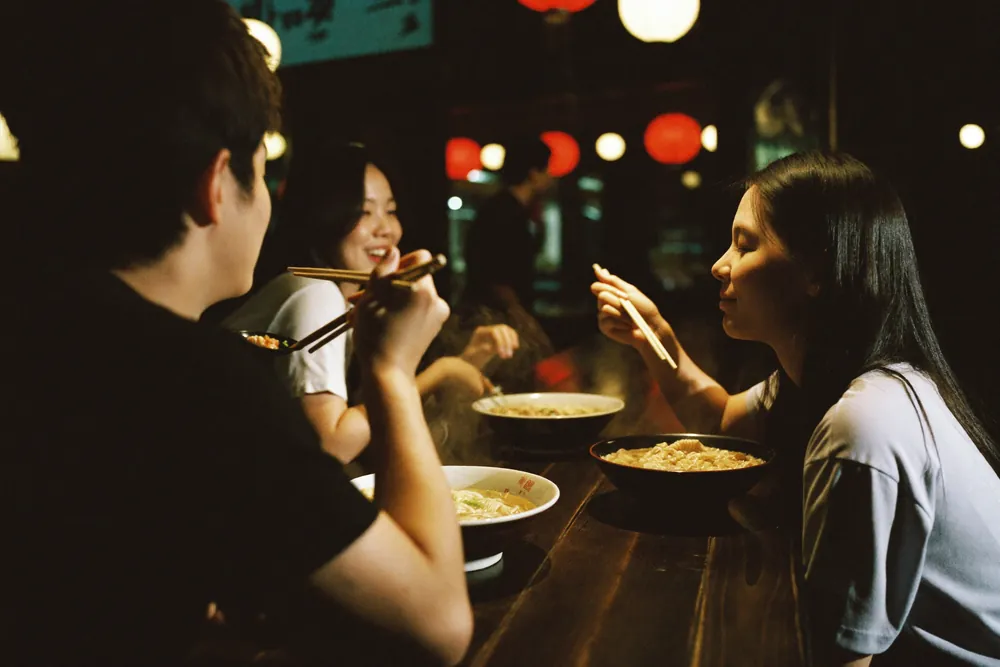 Two guests eating ramen at the counter