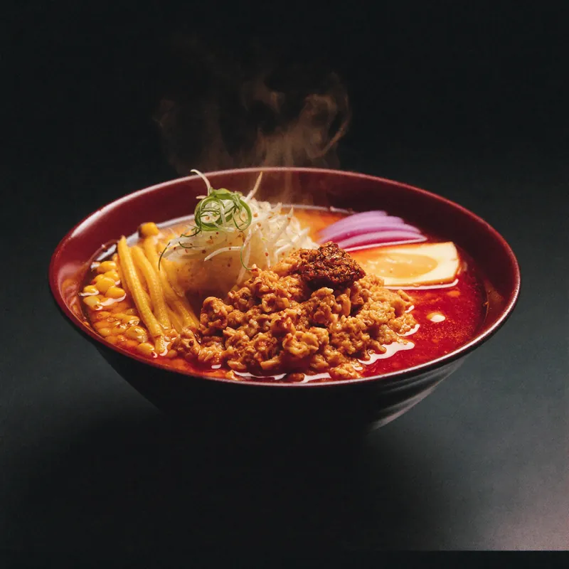 Flaming Spicy Miso ramen with chilli oil in a red-glazed bowl